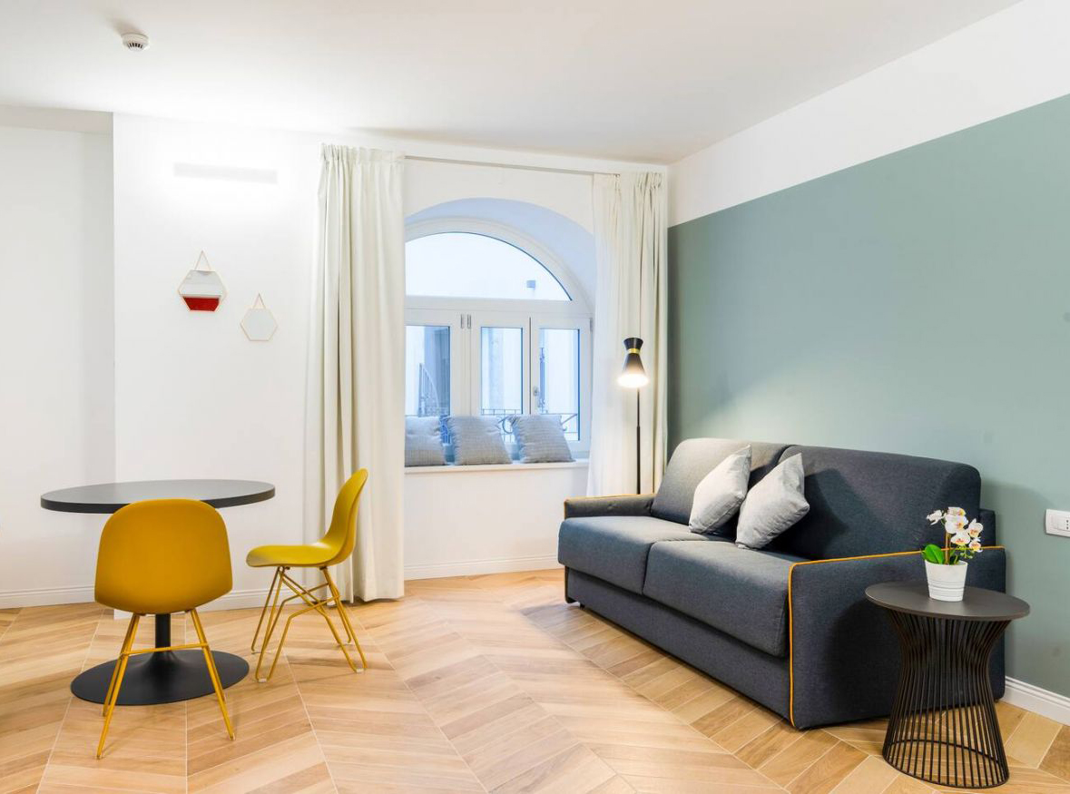 Modern Deluxe Suite with warm wooden floors and a comfortable seating area.