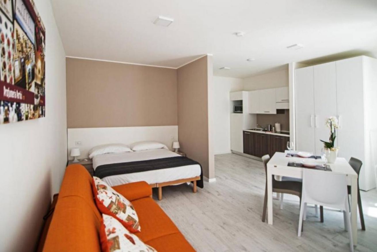 Spacious Studio Plus featuring a seating area, dining table, and modern kitchen.