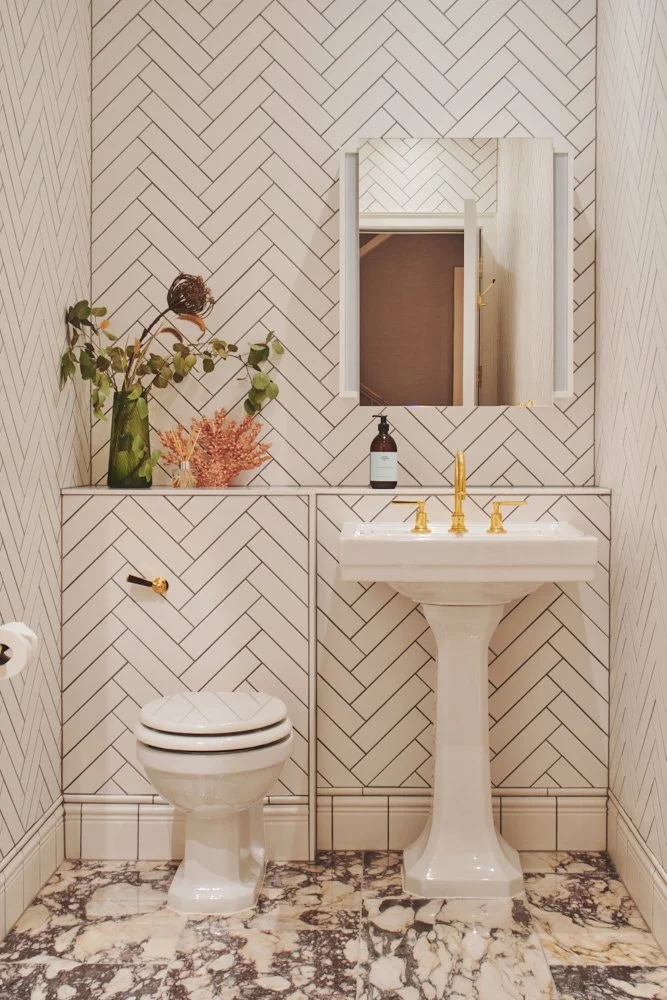 Elegant entrance hall featuring rich burgundy ceramic wall tiles and polished wooden flooring with sophisticated lighting and classical architectural elements